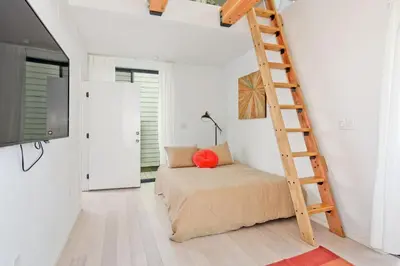 a bedroom with a bed and a ladder at New Beach House, Steps to Sand in San Diego