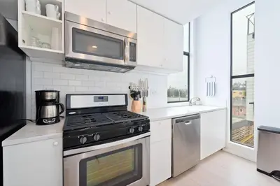 a kitchen with a stove and a microwave at New Beach House, Steps to Sand in San Diego
