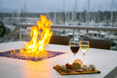 a table with two glasses of wine and a fire pit at Bay Club Hotel and Marina in San Diego