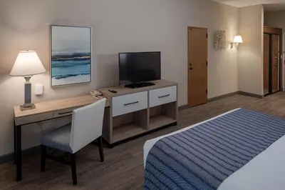 a hotel room with a desk with a television and a bed at Bay Club Hotel and Marina in San Diego