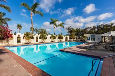 a large swimming pool with palm trees in the background at Bahia Resort Hotel in San Diego