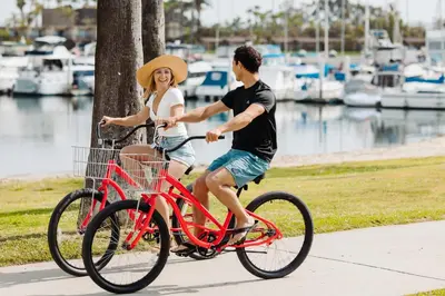 a man and a woman riding a red bike at Bahia Resort Hotel in San Diego
