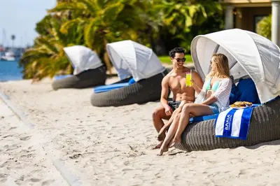 a man and a woman sitting on the beach at Bahia Resort Hotel in San Diego