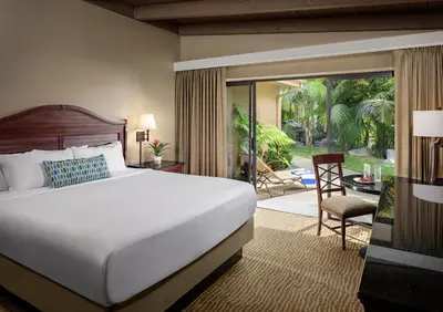 a bedroom with a large bed and a patio at Bahia Resort Hotel in San Diego
