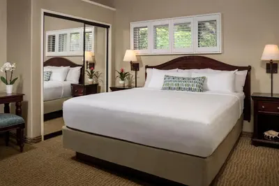 a bedroom with a large white bed and two windows at Bahia Resort Hotel in San Diego