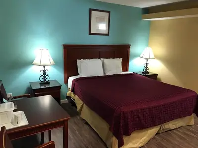 a hotel room with a bed and two tables and two lamps at Travelodge by Wyndham San Diego SeaWorld in San Diego
