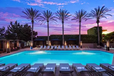 a pool with chairs and palm trees at dusk at San Diego Marriott Del Mar in San Diego