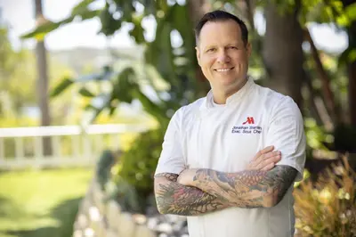 a man with a tattoo on his arm standing with his arms crossed at Newport Beach Marriott Bayview in Newport Beach