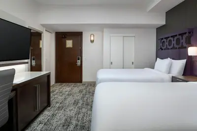 a hotel room with two beds and a flat screen tv at Courtyard by Marriott San Diego Downtown in San Diego