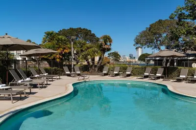a swimming pool with lounge chairs and umbrellas at Coronado Island Marriott Resort & Spa in San Diego