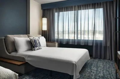 a bedroom with a bed and a couch and a window at Courtyard by Marriott San Diego Mission Valley/Hotel Circle in San Diego