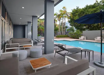 a pool with chairs and tables and an umbrella at Courtyard by Marriott San Diego Mission Valley/Hotel Circle in San Diego