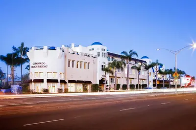 a building on the side of a street with palm trees at Coronado Beach Resort in San Diego