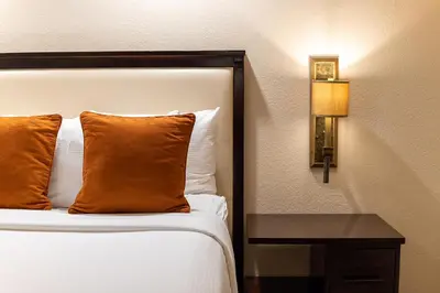 a bed with an orange pillow and a side table at Coronado Beach Resort in San Diego
