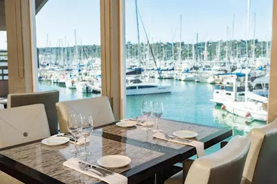 a table with wine glasses and a view of a marina at Humphreys Half Moon Inn in San Diego