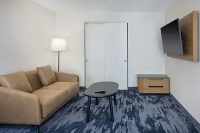a living room with a couch and a table and a tv at Fairfield by Marriott Mission Viejo Orange County in Mission Viejo