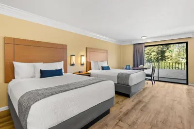 a hotel room with two beds and a balcony at Travelodge by Wyndham San Clemente Beach in San Clemente