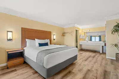 a bedroom with a large bed and a bathroom at Travelodge by Wyndham San Clemente Beach in San Clemente