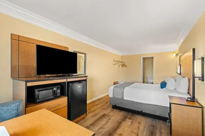 a hotel room with a bed and a flat screen tv at Travelodge by Wyndham San Clemente Beach in San Clemente