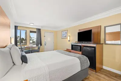 a hotel room with a bed and a flat screen tv at Travelodge by Wyndham San Clemente Beach in San Clemente