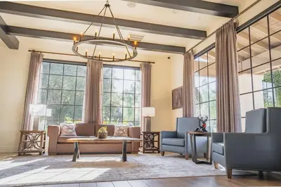 a living room with a couch and chairs and large windows at Riviera Oaks Resort in Ramona