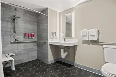 a bathroom with a shower and a sink and a toilet at SureStay Hotel by Best Western San Diego Pacific Beach in San Diego