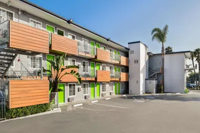 an apartment building with orange and green accents at SureStay Hotel by Best Western San Diego Pacific Beach in San Diego