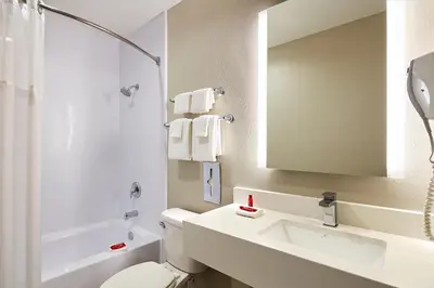 a bathroom with a sink and a toilet and a mirror at SureStay Hotel by Best Western San Diego Pacific Beach in San Diego