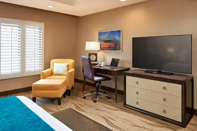 a hotel room with a bed and a desk and a television at Empress Hotel La Jolla in San Diego