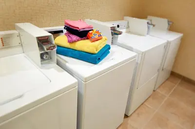 a pile of towels on top of a washer and dryer at Empress Hotel La Jolla in San Diego