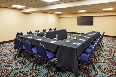 a conference room with a long table and blue chairs at Empress Hotel La Jolla in San Diego