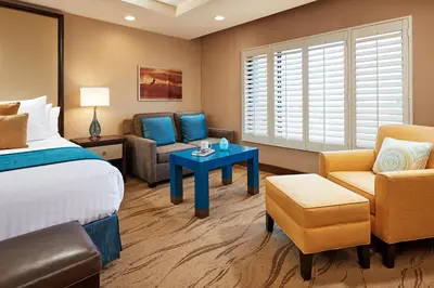 a hotel room with a bed and a couch and a table at Empress Hotel La Jolla in San Diego