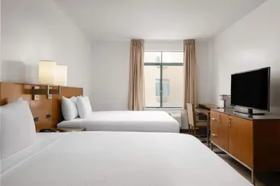 a hotel room with two beds and a flat screen tv at Ramada Suites by Wyndham San Diego Hotel Circle Area in San Diego