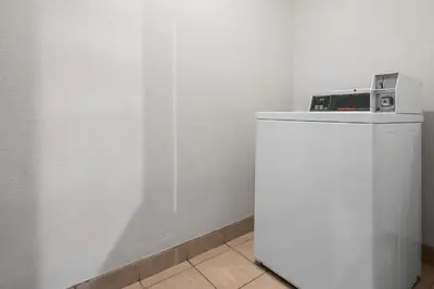 a microwave sitting on top of a white refrigerator at Ramada Suites by Wyndham San Diego Hotel Circle Area in San Diego