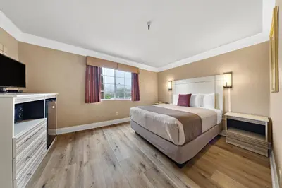 a hotel room with a bed and a television at Americas Best Value Inn San Clemente Beach in San Clemente