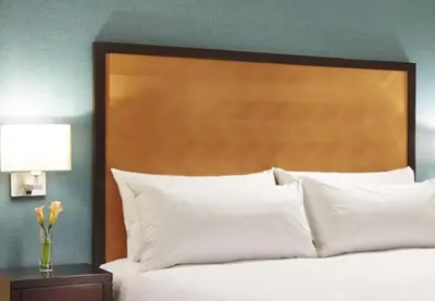 a bed with a large wooden headboard and white pillows at Hampton Inn San Diego Mission Valley in San Diego
