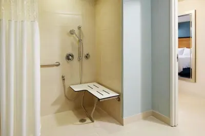 a shower stall with a bench in a bathroom at Hampton Inn San Diego Mission Valley in San Diego