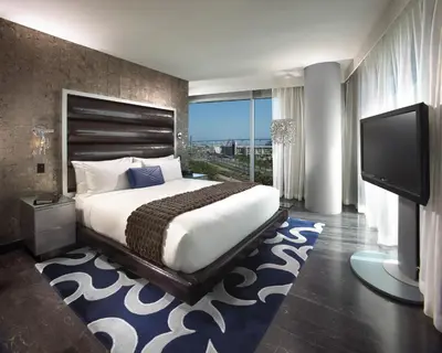 a bedroom with a large bed and a flat screen tv at Hard Rock Hotel San Diego in San Diego