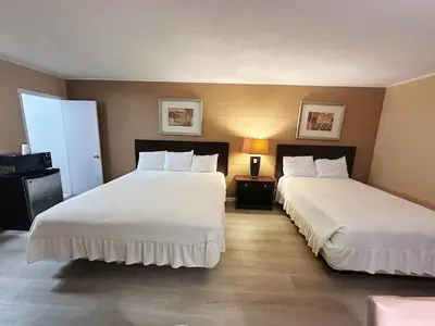 two beds in a hotel room with two bedsskirts at Royal Inn and Suites in Hemet