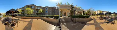 a building with a courtyard with tables and chairs at Hilton Garden Inn San Diego Del Mar in San Diego