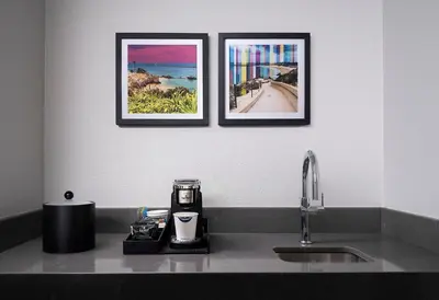 two framed pictures on a wall above a kitchen sink at Hampton Inn San Diego/Del Mar in San Diego