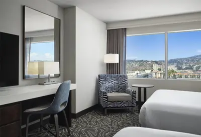 a hotel room with a bed and a desk and chair at Hilton San Diego Mission Valley in San Diego