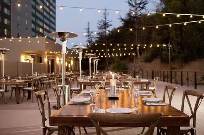 a wooden tables and chairs on a patio with lights at Hilton San Diego Mission Valley in San Diego