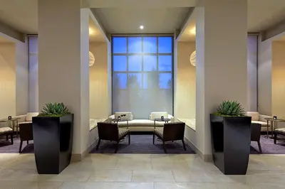 a waiting room with tables and chairs and a large window at Hilton San Diego Mission Valley in San Diego