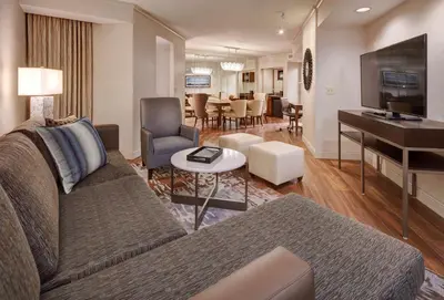 a living room with a couch and a piano at Embassy Suites by Hilton San Diego La Jolla in San Diego