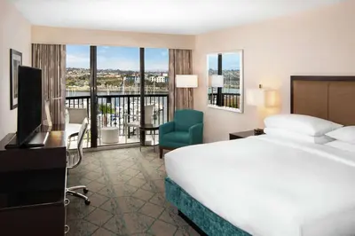 a hotel room with a bed and a television and a balcony at Hilton San Diego Airport/Harbor Island in San Diego
