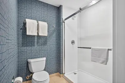 a bathroom with a toilet and a shower with blue tiles at Homewood Suites by Hilton Carlsbad-North San Diego County in Carlsbad