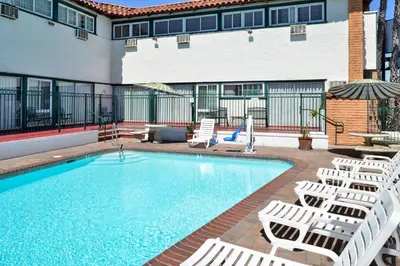 a pool with chaise lounge chairs and a hotel at Americas Best Value Inn Loma Lodge in San Diego