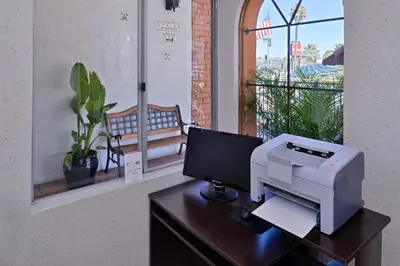 a computer sitting on a desk with a printer at Americas Best Value Inn Loma Lodge in San Diego