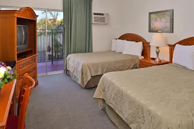 a hotel room with two beds and a television at Americas Best Value Inn Loma Lodge in San Diego
